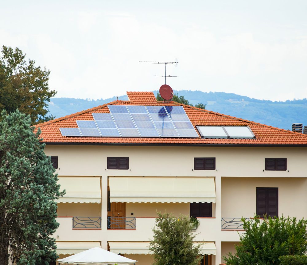Photovoltaic solar panel on a roof. In background gray cloudy sky.